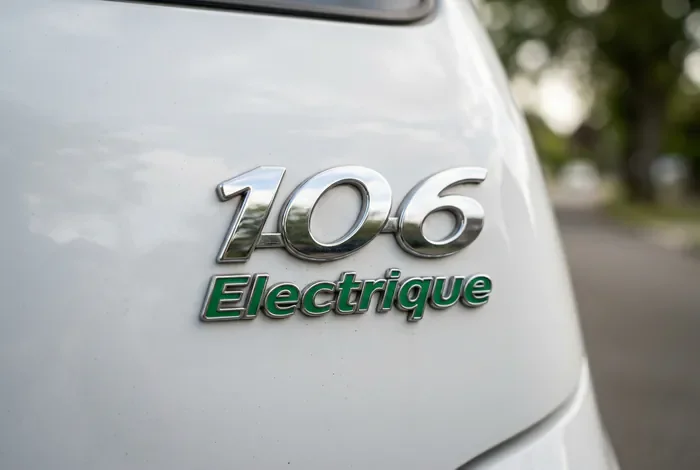 Gros plan sur le badge vert et chromé 106 Électrique sur le hayon arrière.